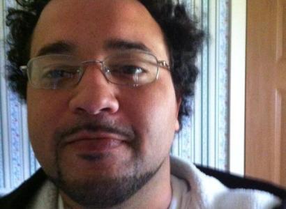 Young man with wire rimmed glasses and goatee