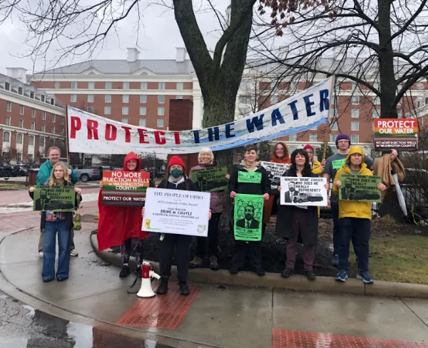 Protesters outside under Protect our Water banner