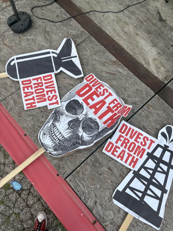 Skuk=ll signs saying Divest from Death