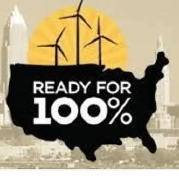 A black map of the USA with words Ready for 100% in white on it, above it three windmills and the skyline of Columbus in the background