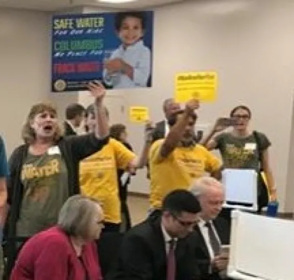 Lots of people holding signs in a room together yelling