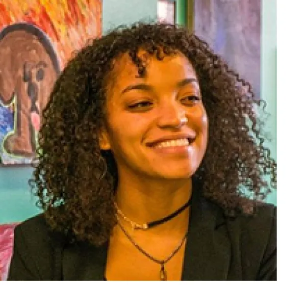 Young black woman smiling with curly shoulder length hair