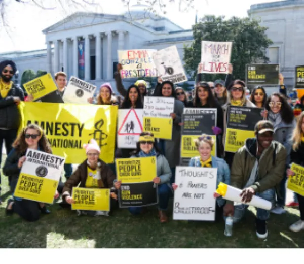 People posing outside with Amnesty signs