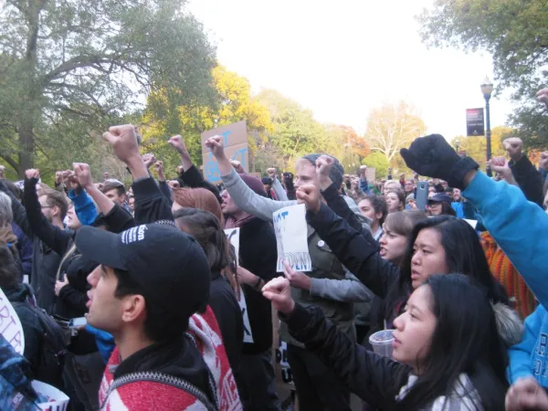 People with their fists in the air at an anti-Trump rally