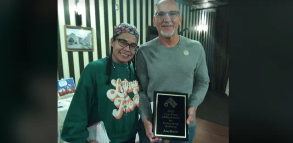 Woman and man with award