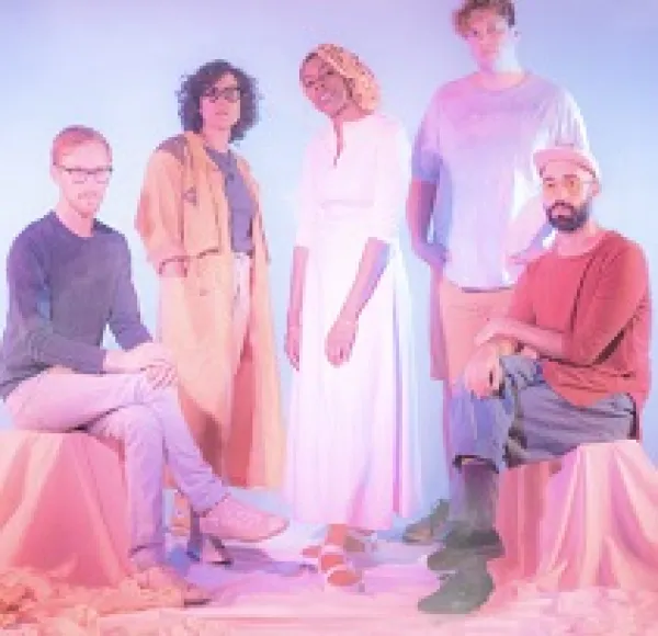 Five people posing two sitting on each side and three standing in the middle