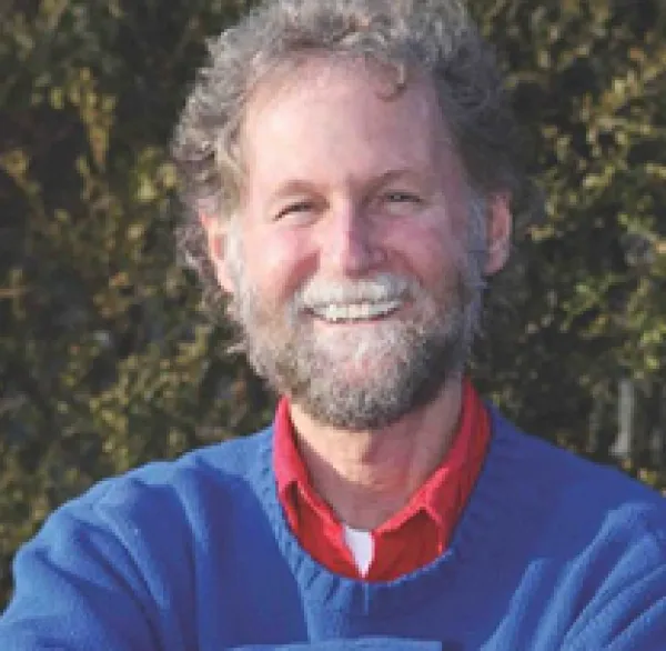 Smiling white man head and shoulders, he has mustache and beard and blue sweater