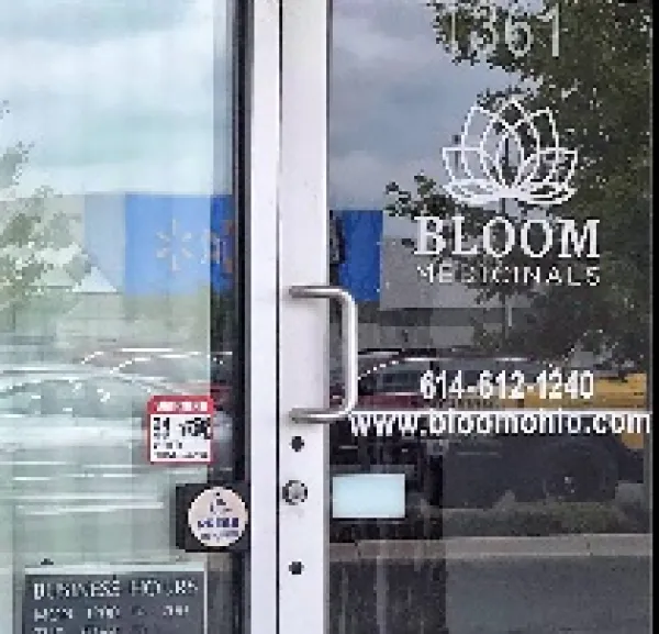 Glass front door of business with words Bloom Medicinals