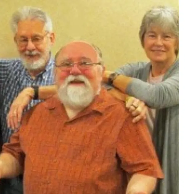 Two Gray haired men and a gray haired lady posing and smiling