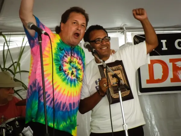 Two men on stage holding their fists in the air