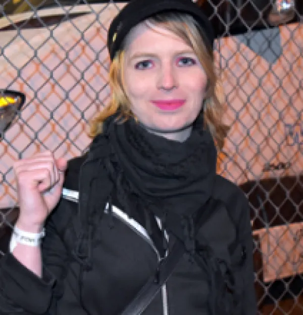 Young blonde woman in a black outfit raising her fist