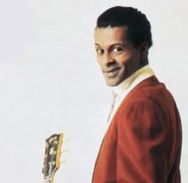 Black man in red suit holding a guitar