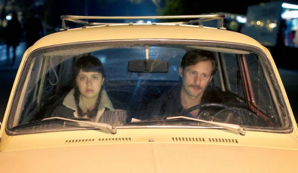 Man and young woman in front seat of car
