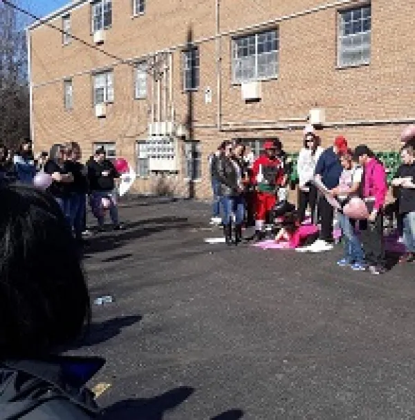 People outside a brick building with posters and signs