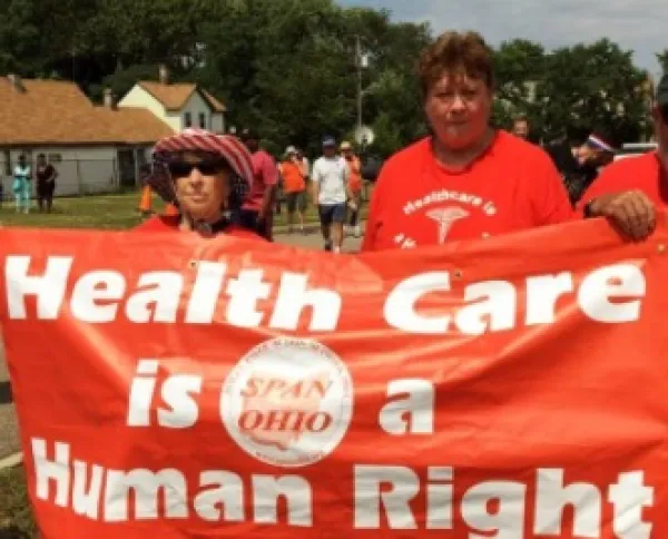 People marching holding sign
