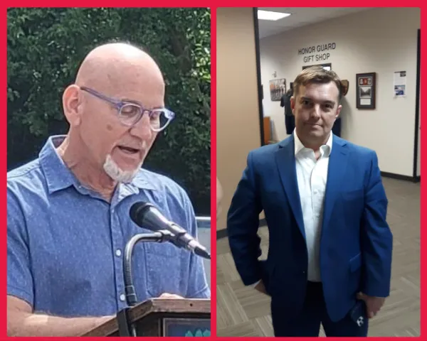 Man at a microphone and another looking on