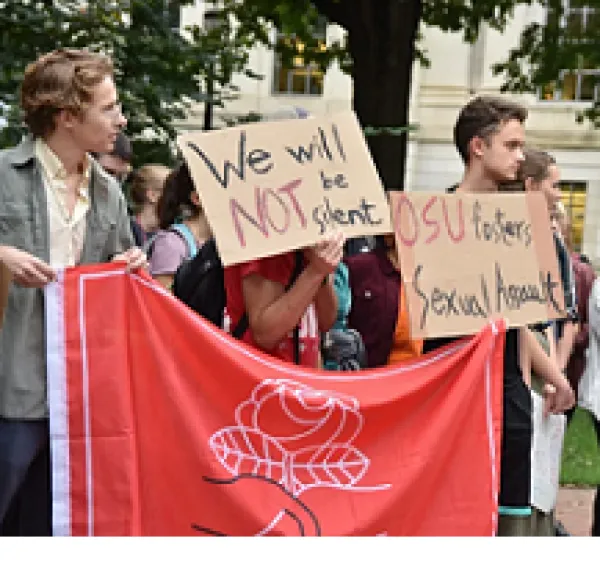 Young white people holding a big DSA sign marching
