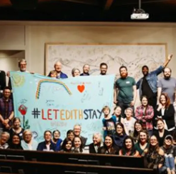 People posing with a sign saying Let Edith Stay