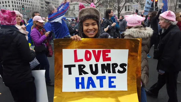Young woman holding Love Trumps Hate sign