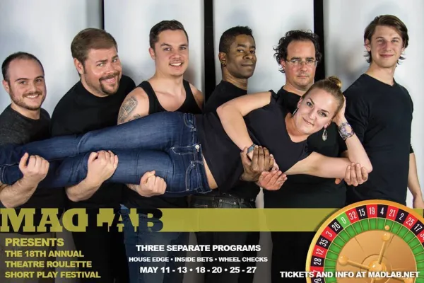 Men wearing black holding a woman laying on her side