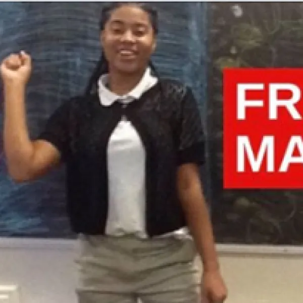 Young black woman smiling and raising her fist in the air