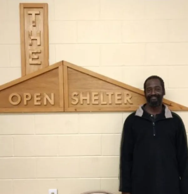 Open Shelter sign and man standing next to it