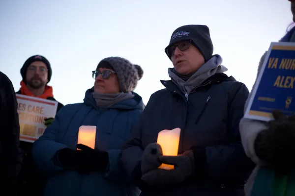 People outside holding candles