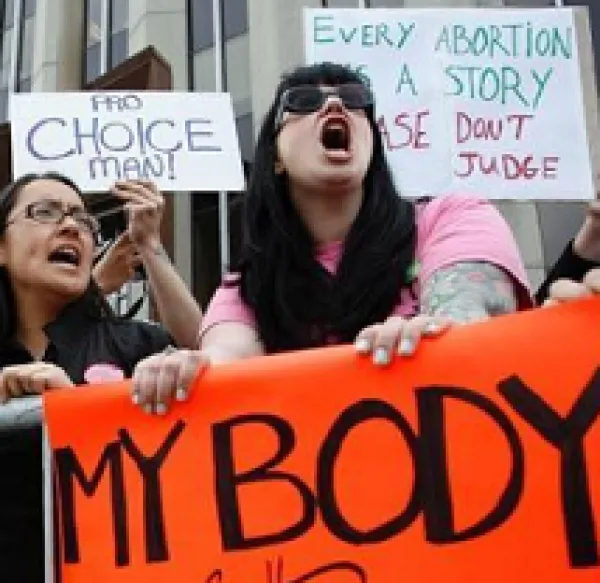 Women outside yelling at a protest with signs that say My Body My Choice