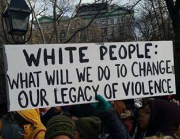 Banner saying White People What will we do to change our legacy of violence