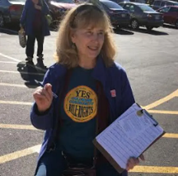 Blonde woman in blue t-shirt with a clipboard