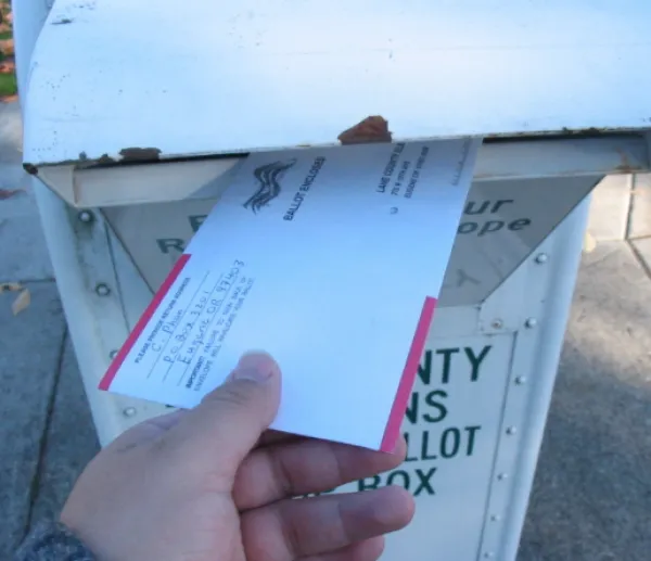Hand putting mail in mailbox