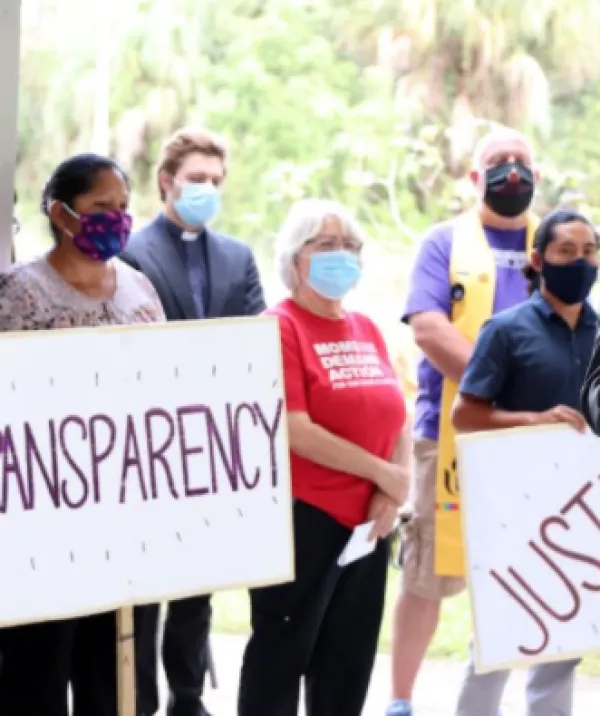 People with signs saying Transparency and Justice