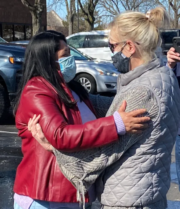 Miriam embracing another person