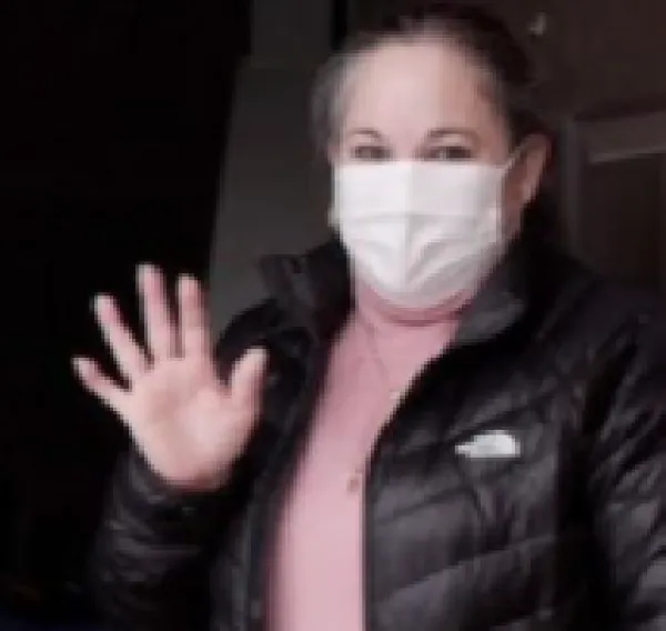 Edith waving in a doorway