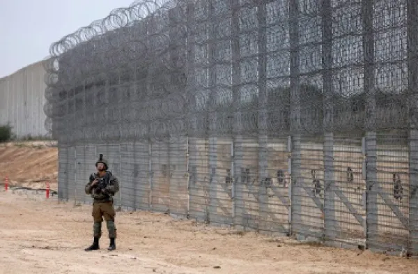 Man standing outside a wall of fences