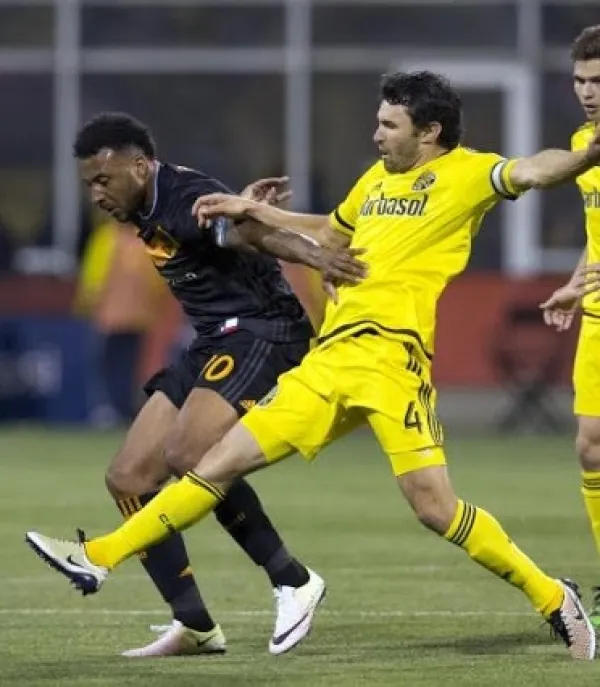 Two soccer players going after the ball