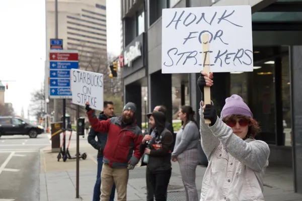 People outside striking with signs