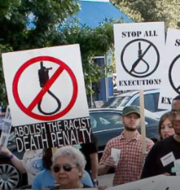 People marching with signs that say Abolish the Death Penalty and Stop Executions