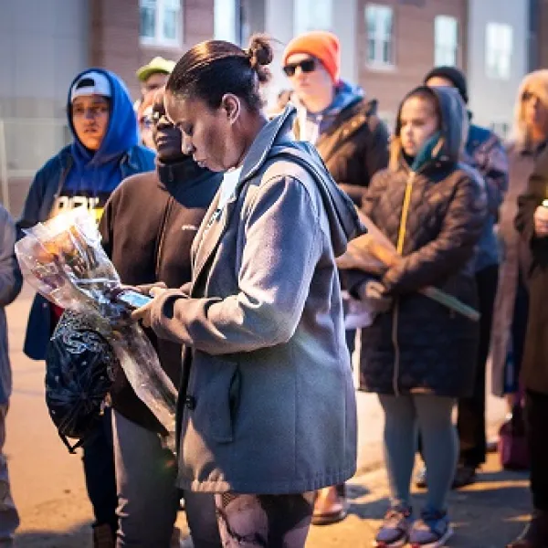 Black woman surrounded by people outside