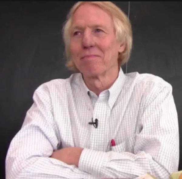 Man in white shirt leaning elbows on table