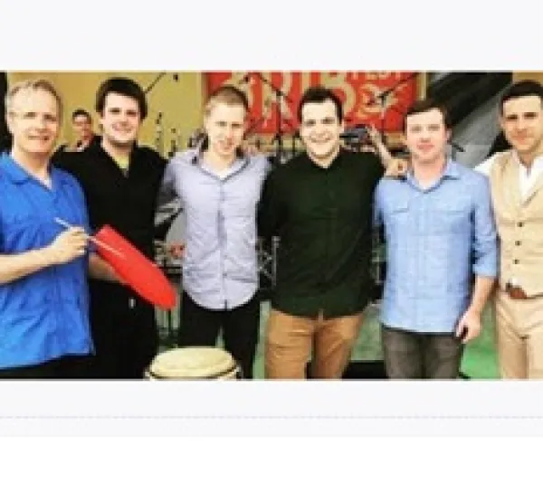 Six white men posing in a line with musical instruments