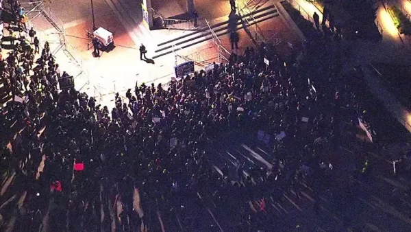 A person on a stage and the audience from a view high up above in the rafters.