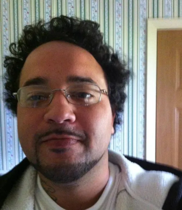 Photo of young black man with wire-rimmed glasses