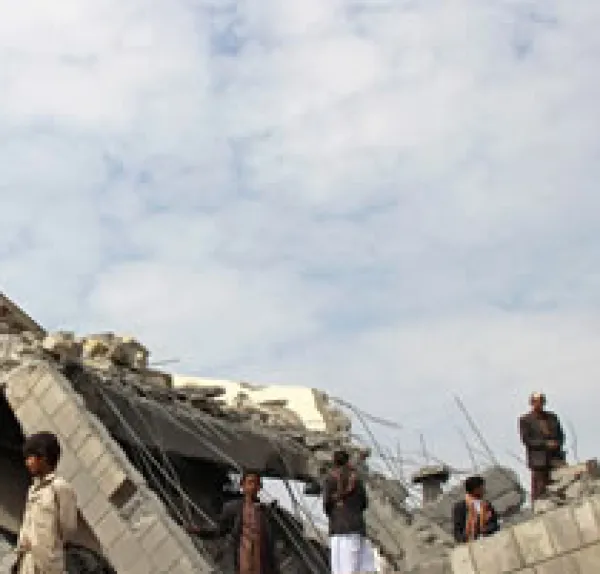 Broken down building against cloudy sky with young man standing around looking lost