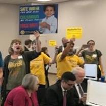 Lots of people holding signs in a room together yelling