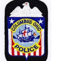 A patch with a white eagle on top, red, white and blue with stars and stripes and the words Columbus Police and what looks like the Santa Maria in the middle