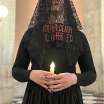 Woman in funeral clothes with a candle