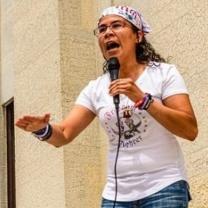 Esther Flores passionately talking into a mic