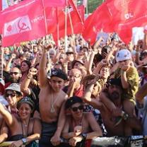 Hundreds of people outside waving lots of red flags