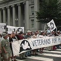 People holding a banner that says Veterans for Peace standing in front of a government building